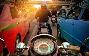 motorcycles riding between cars